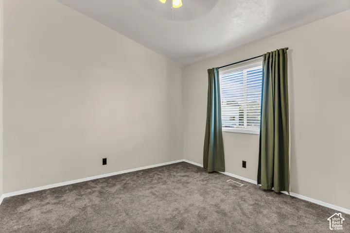 Neutral tone walls with gray carpeting and a white window frame