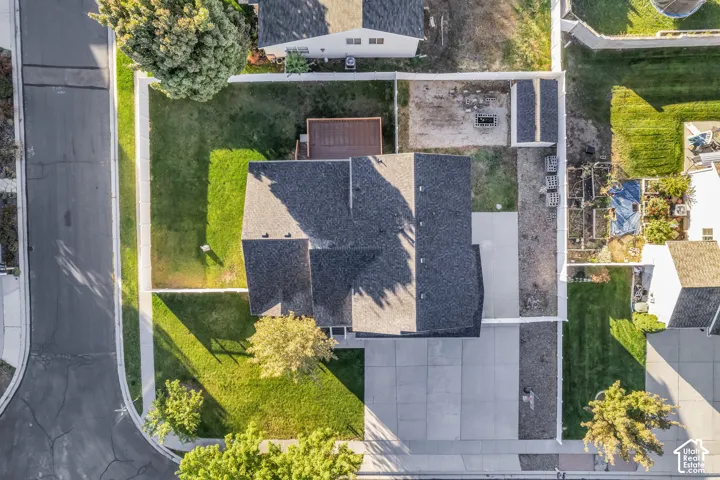 Expansive lot featuring a large paved driveway, a manicured front lawn, and a fenced backyard with a wood deck
