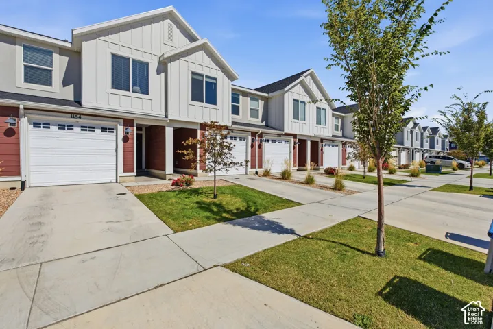 Townhome exterior featuring board and batten siding, attached garage, and concrete driveway