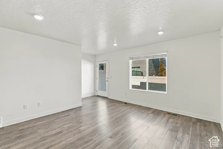 Wood-finish flooring, recessed lighting, white walls, and a white-framed window