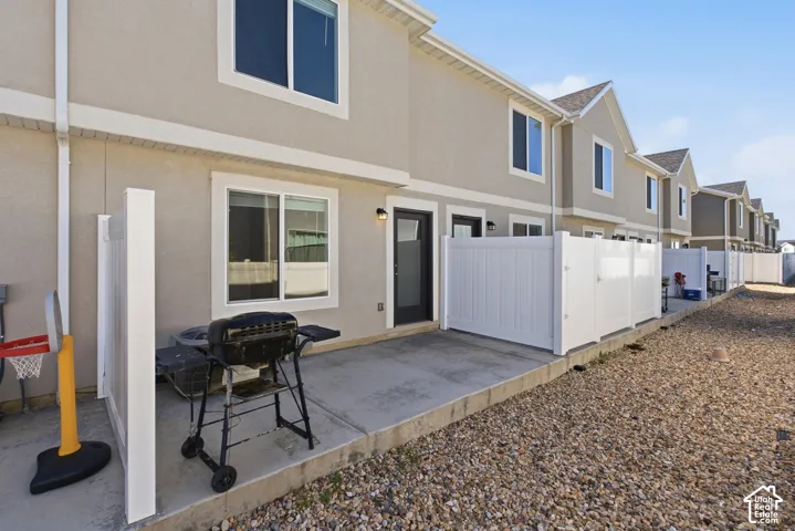 Private concrete patio area with white privacy fencing and exterior lighting