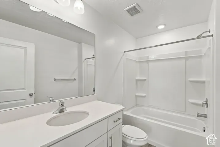 White vanity with an integrated sink, polished chrome faucet, and expansive wall mirror