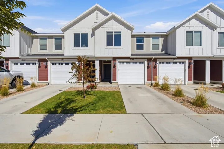 Contemporary townhome exterior featuring white vertical siding and red horizontal siding accents
