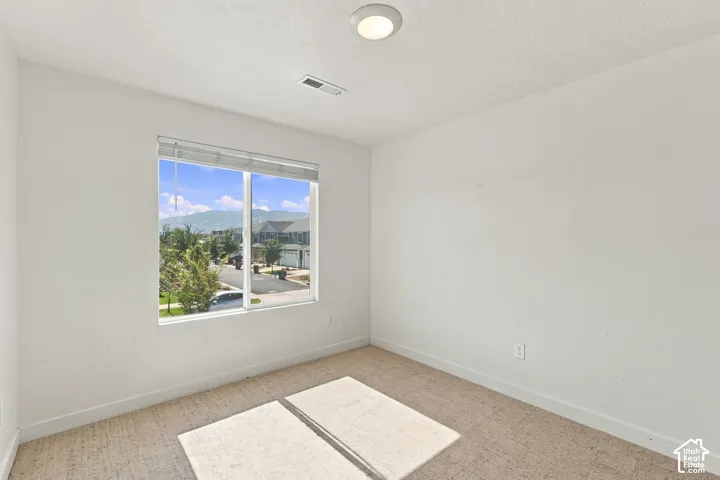 Bright interior with a large window, carpet flooring, white walls, and a flush mount ceiling light
