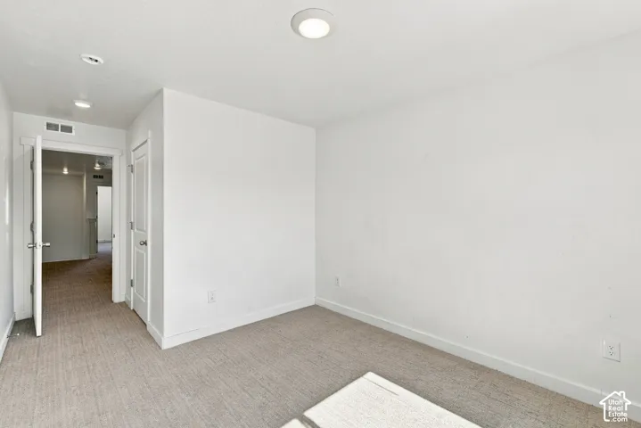 Recessed ceiling lighting, light-toned carpeting, white walls, and white trim