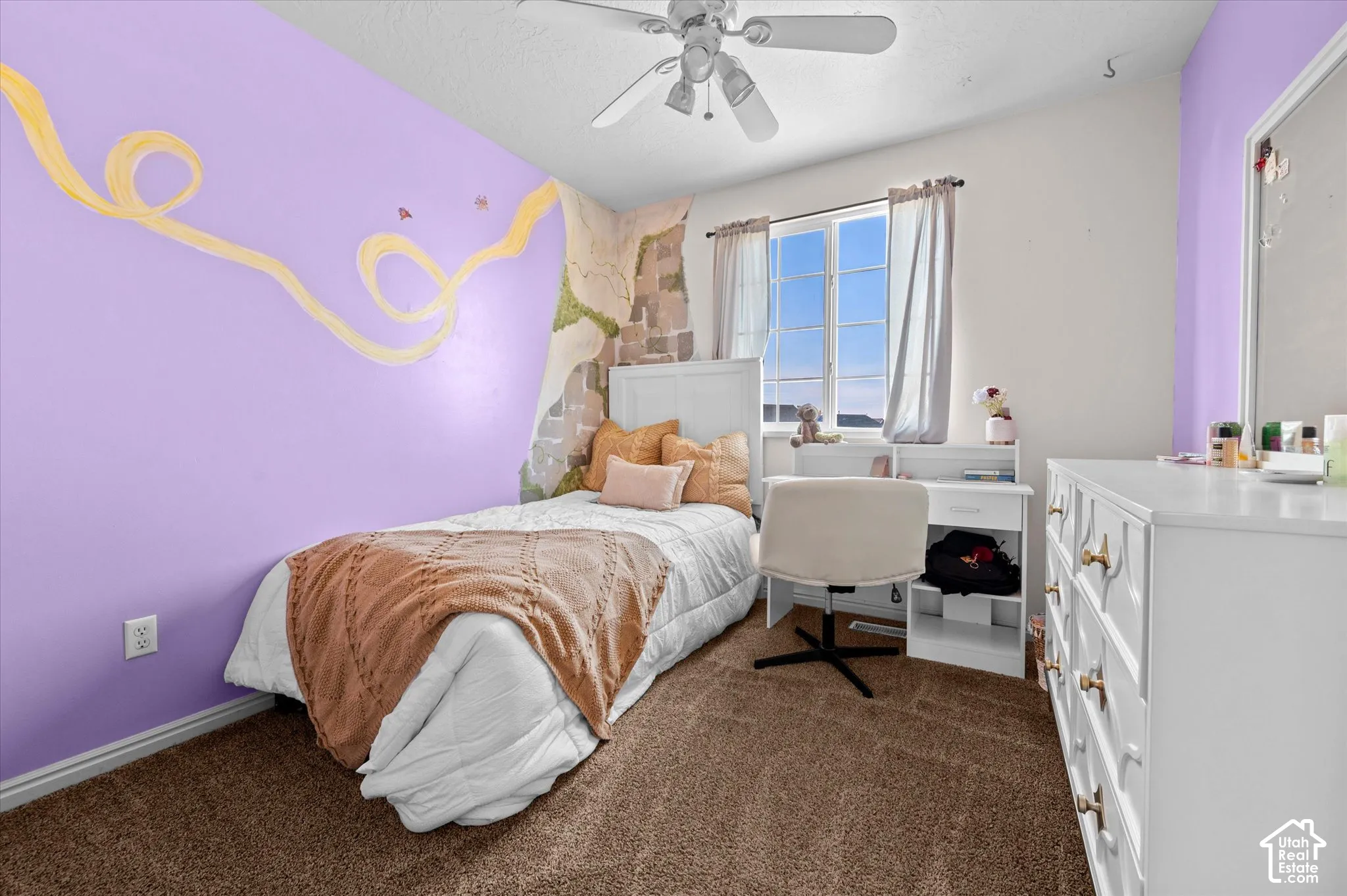 Carpeted flooring, ceiling fan, built-in window desk, and a window with exterior views