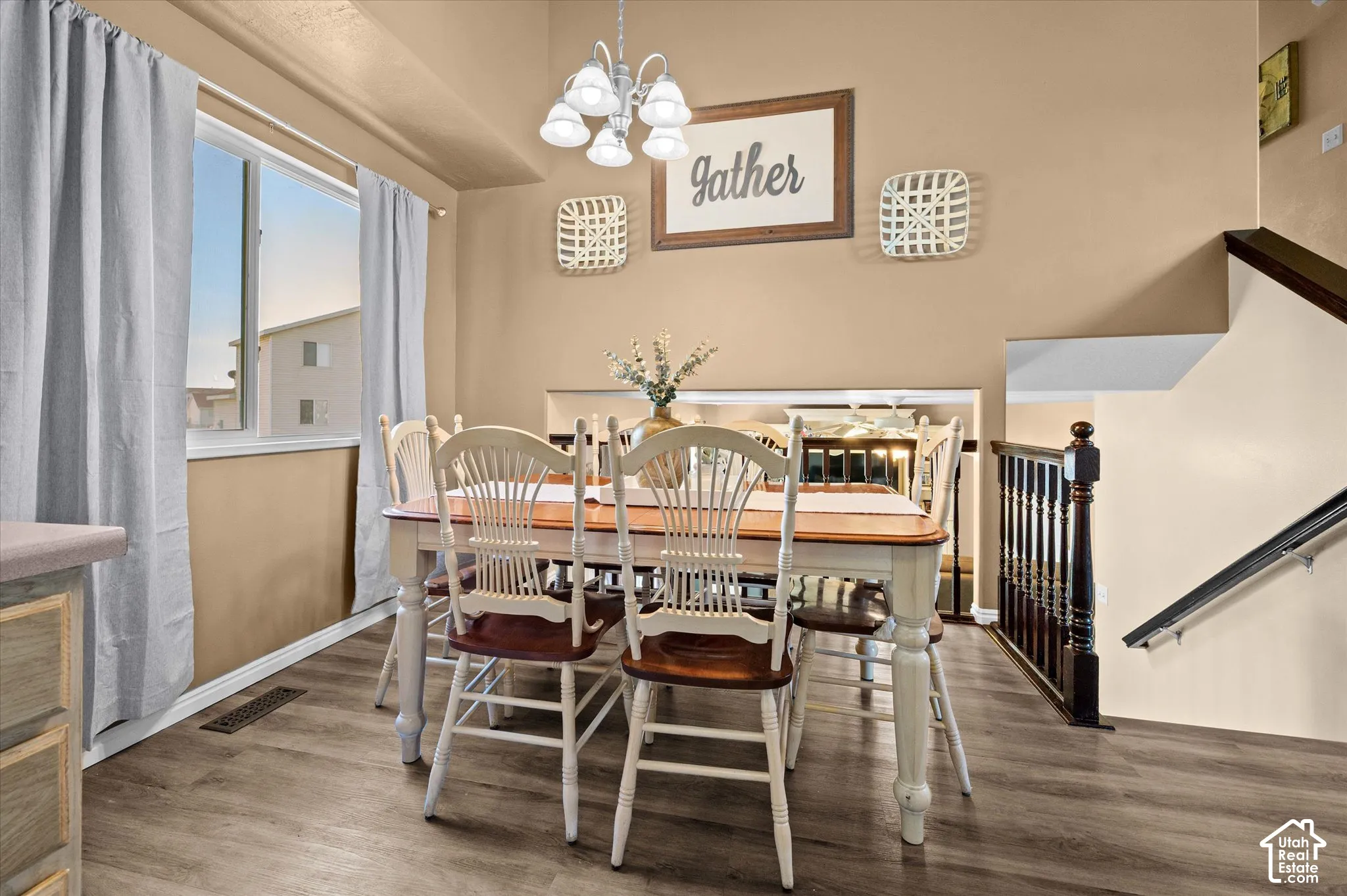 Dining area featuring wood-finish flooring, a window with natural light, and a built-in chandelier