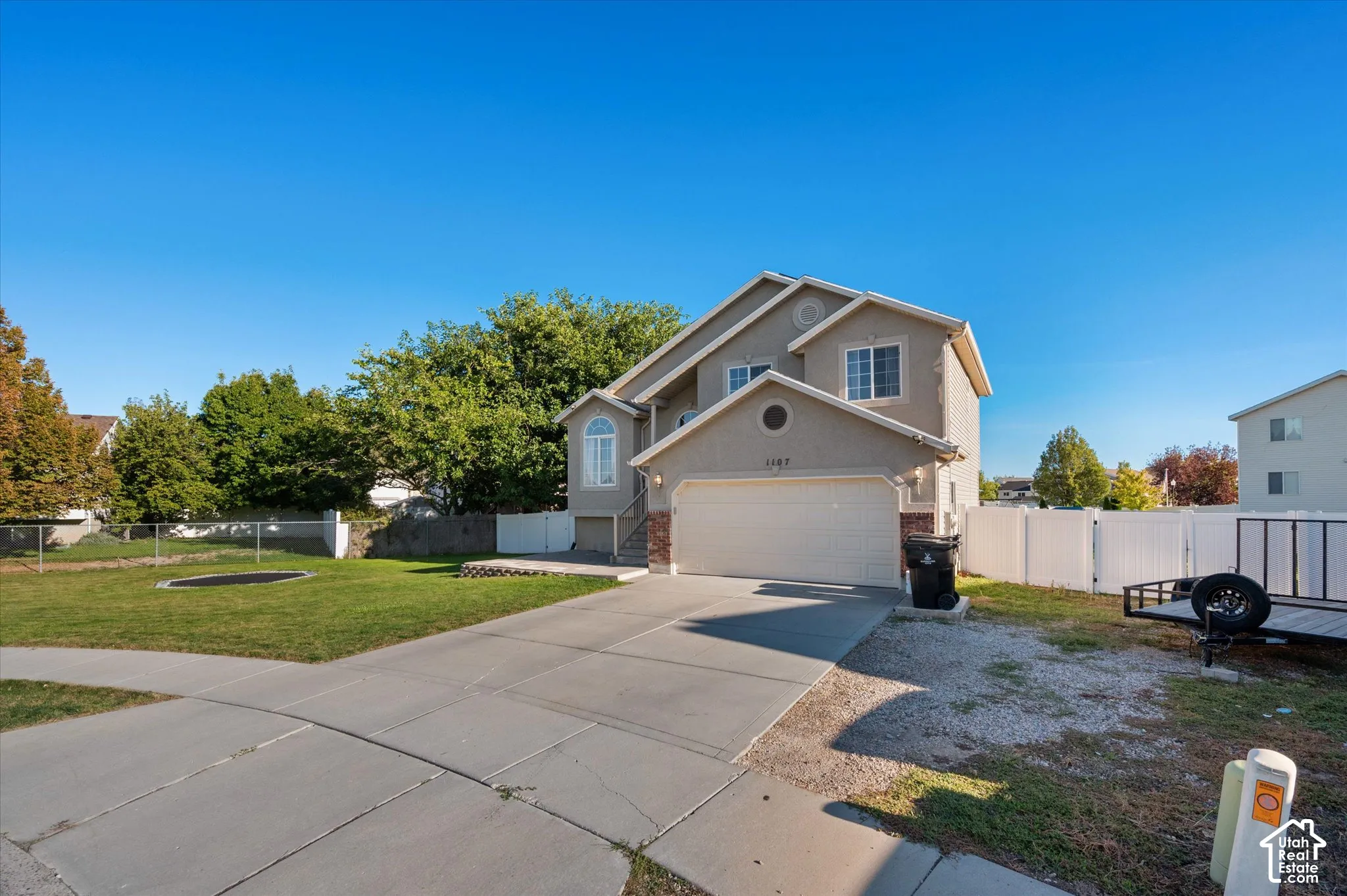 Two-story exterior with a two-car garage, concrete driveway, and side yard
