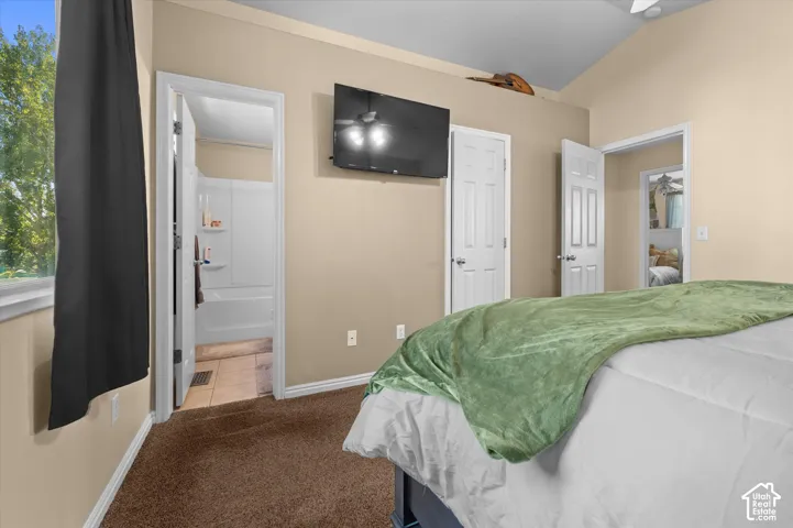Vaulted ceiling, wall-mounted television, and carpeted flooring