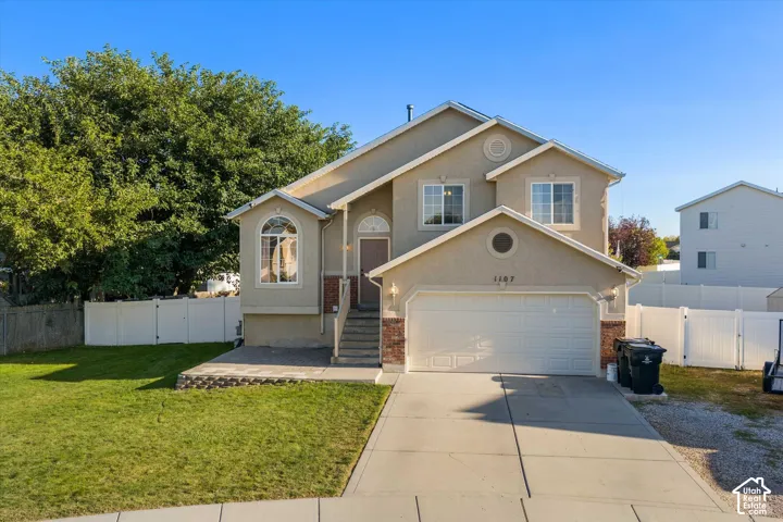 Two-story stucco residence with brick accents, featuring an attached two-car garage and a concrete driveway