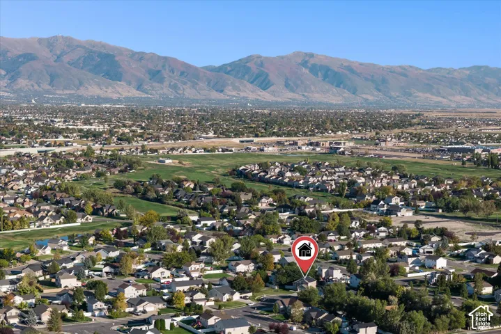 Expansive aerial perspective showcasing a residential neighborhood with distant mountain ranges