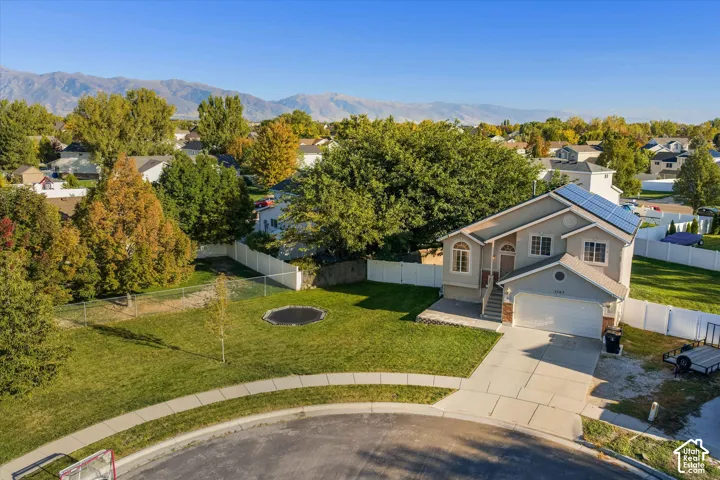 Two-story residence with an attached garage, solar panels, and a concrete driveway