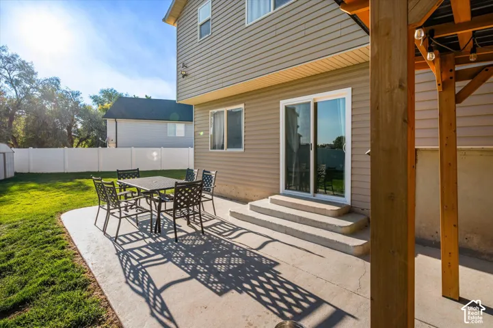Outdoor patio with concrete surface, direct access to the interior via sliding glass doors, and a partial pergola structure