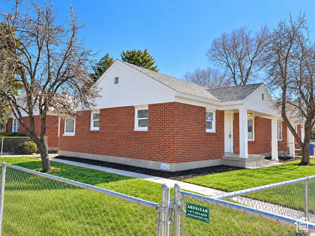 Red brick exterior featuring white trim and a covered front entry