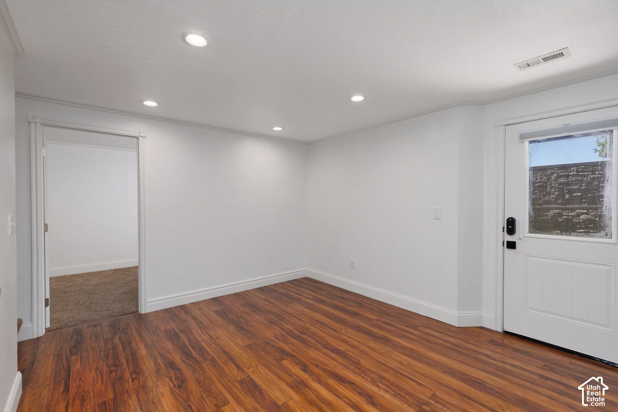 Wood-finish flooring, recessed lighting, and white trim accents