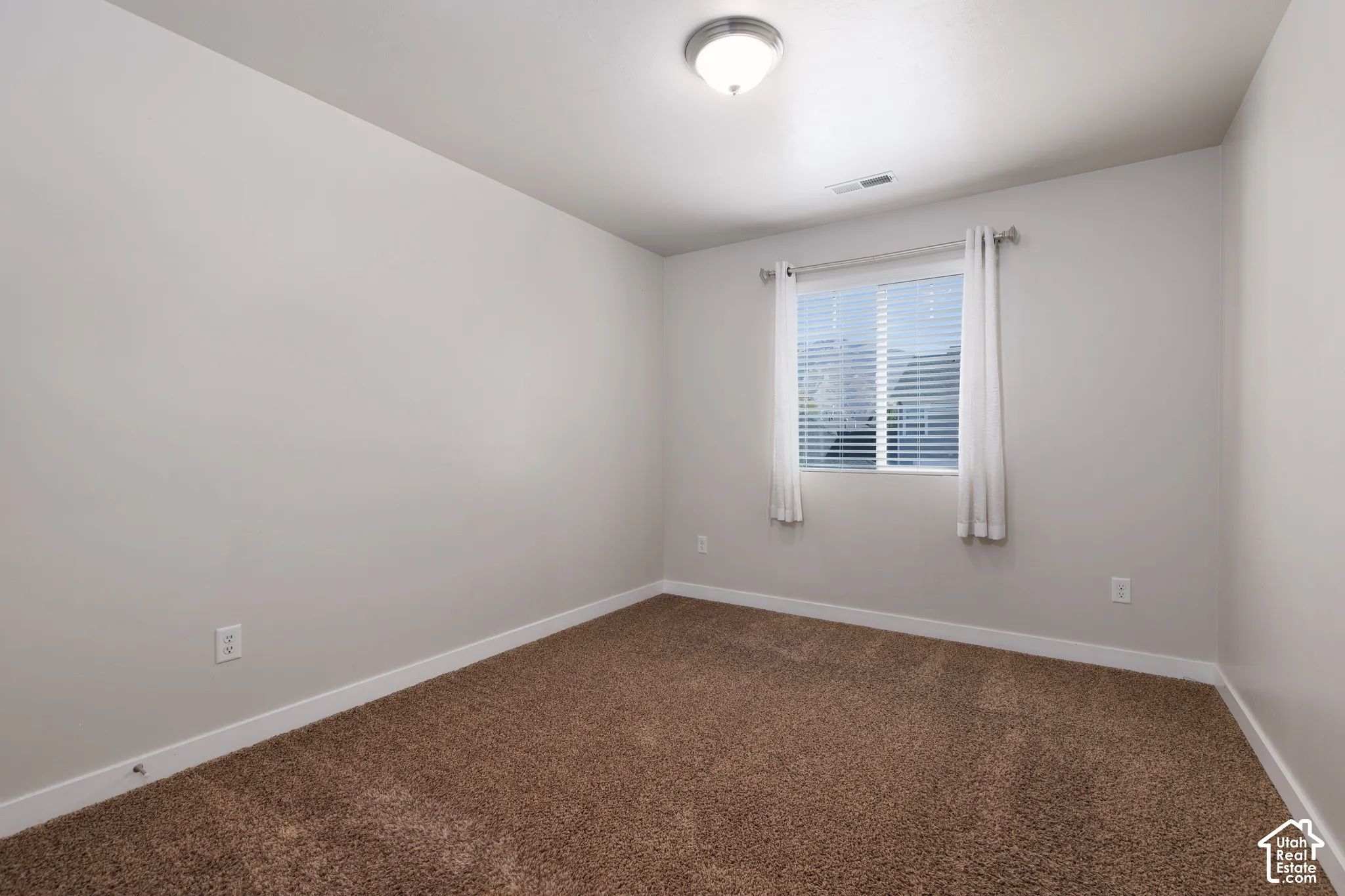 Neutral wall color with recessed window featuring blinds