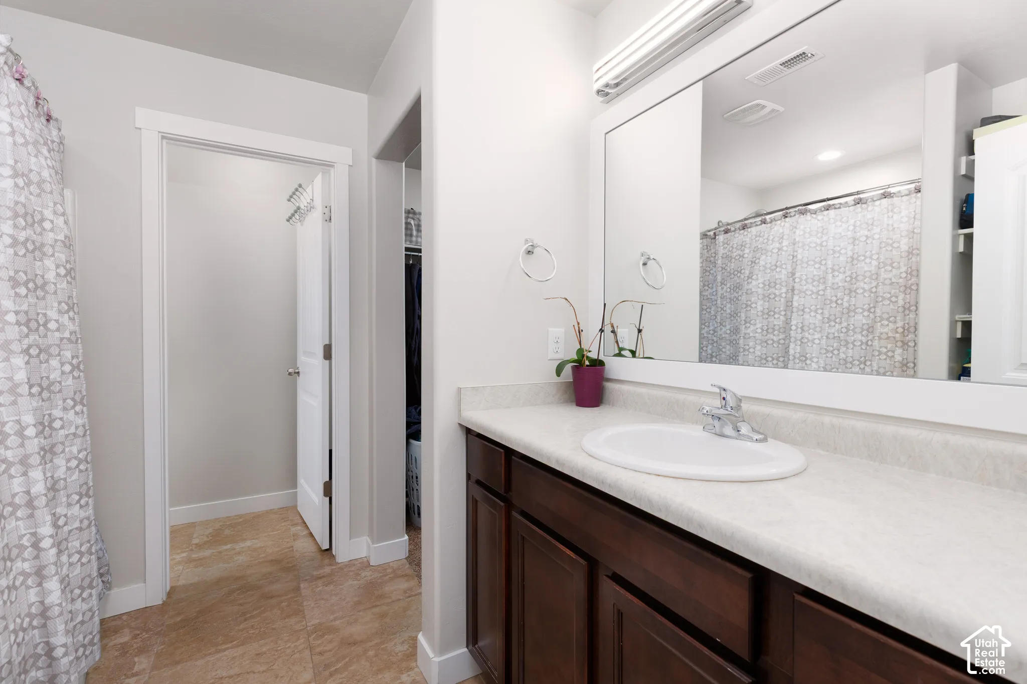 Vanity with an integrated white sink, chrome faucet, and dark wood-finish cabinetry