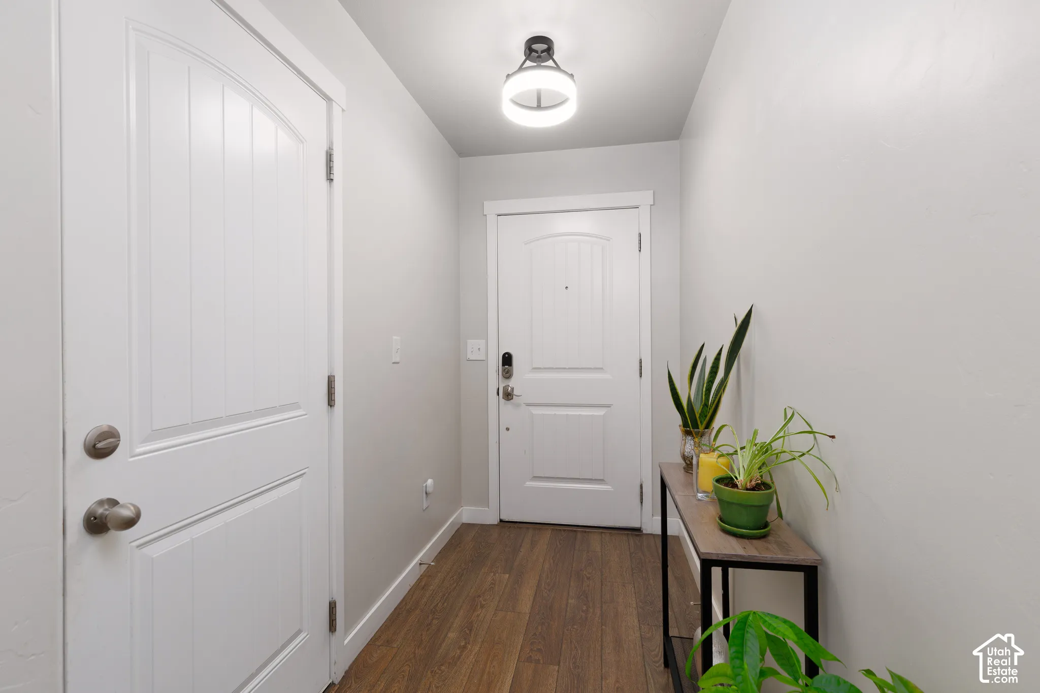 Wood-finish flooring, white walls, and a modern ceiling light fixture