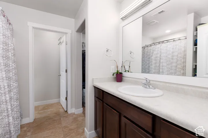 Vanity with an integrated white sink, chrome faucet, and dark wood-finish cabinetry