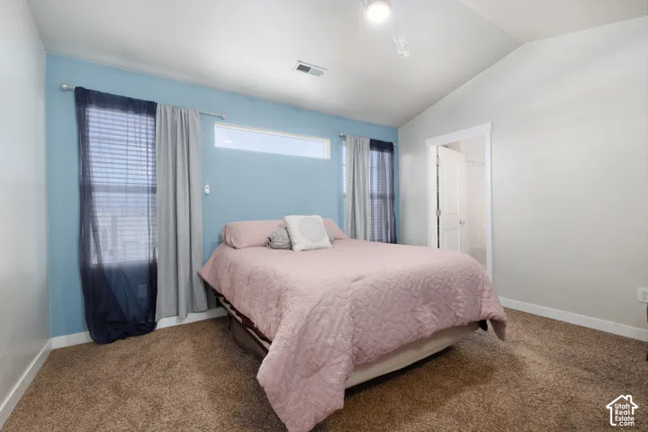 Vaulted ceiling with track lighting, an upper transom window, and a window with blinds