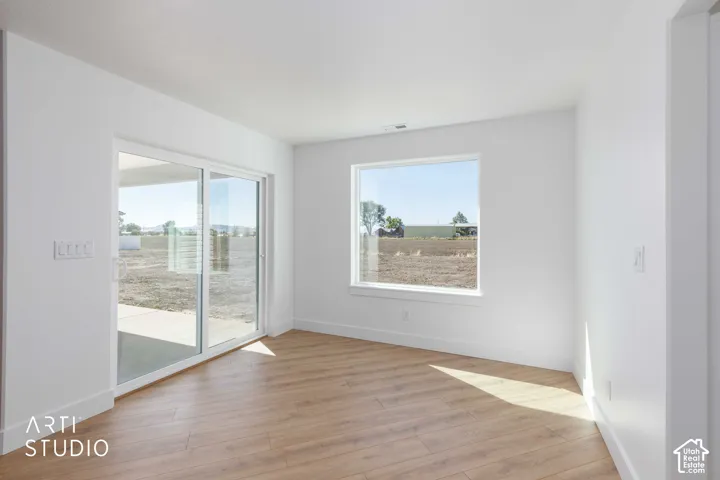 Light wood-finish flooring, white walls, and a large sliding glass door