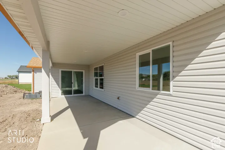 Covered patio with a concrete slab, white vinyl siding, and a sliding glass door