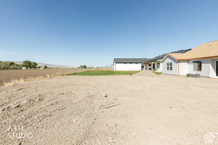 Expansive lot with cleared terrain, partial grass, and distant mountain range