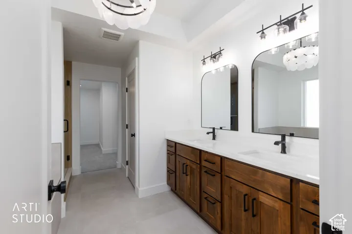 Primary bathroom ensuite with dual vanities with undermount sinks, quartz countertops, and matte black fixtures
