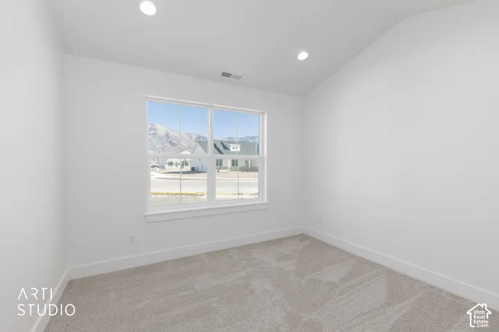 Southeast bedroom featuring a large window, recessed lighting, and light-toned carpeting.