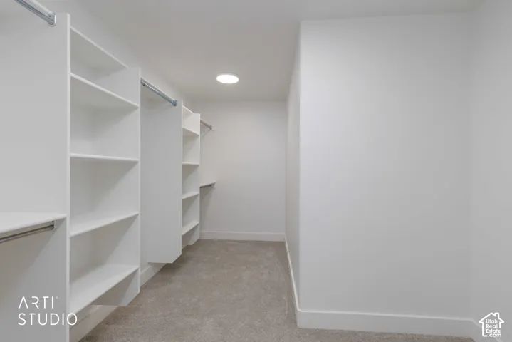 Primary suite closet with built-in shelving with hanging rods