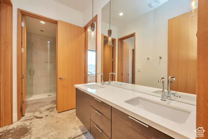Dual vanity with white countertop, chrome fixtures, and wood-finish cabinetry