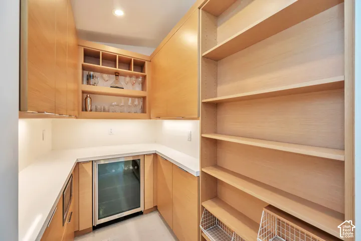 Built-in cabinetry with under-cabinet lighting, wine storage, and integrated beverage refrigerator