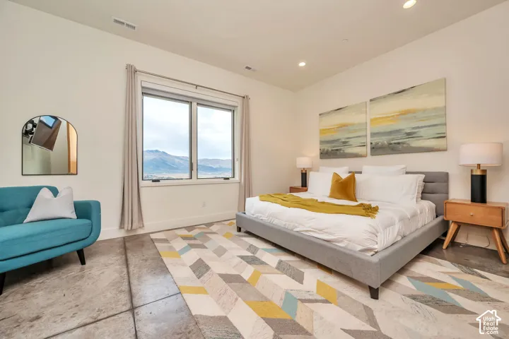 Spacious room featuring concrete flooring, a large window with mountain scenery, and recessed ceiling lighting