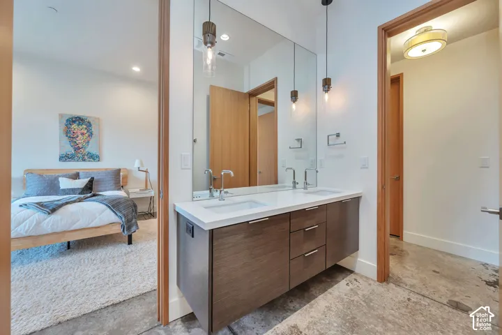 Floating wood-finish vanity with dual vessel sinks, wall-mounted faucets, and an expansive mirror