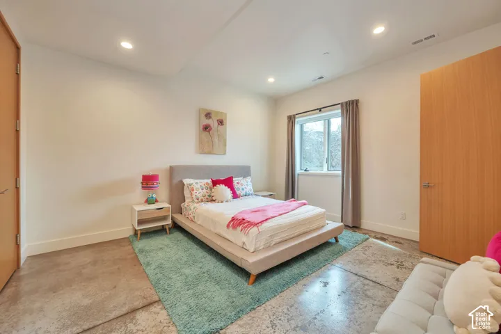 Polished concrete flooring, recessed lighting, wood-finish doors, and a window with window treatments