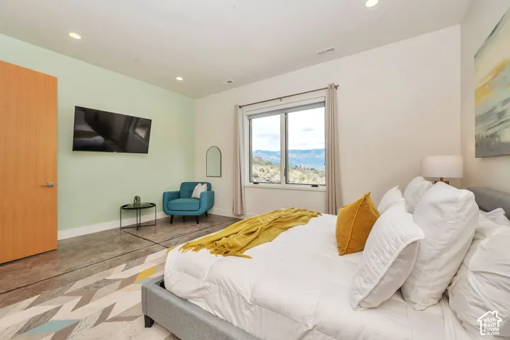 Recessed lighting, wood-finish door, large window with mountain scenery, and concrete flooring