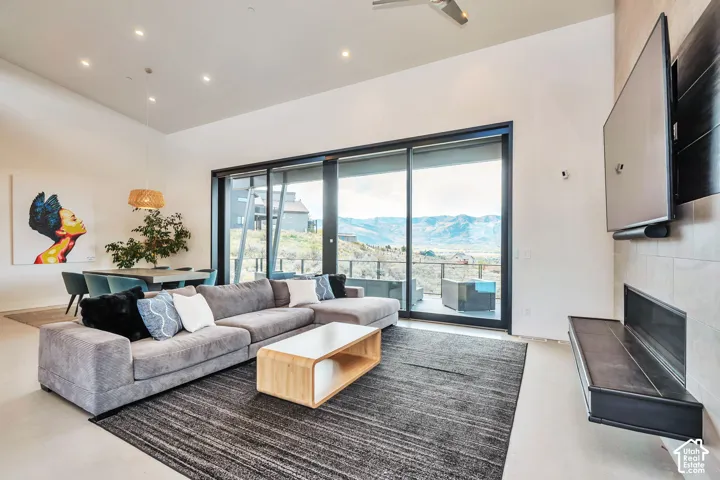 Spacious living area featuring high ceilings, recessed lighting, and a linear fireplace with an integrated hearth