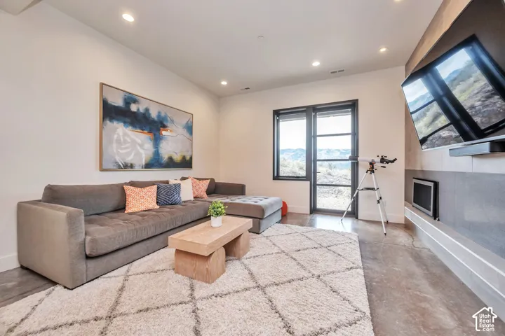 Recessed lighting illuminates the space, featuring a large window with multiple panes and a solid door with a multi-pane design