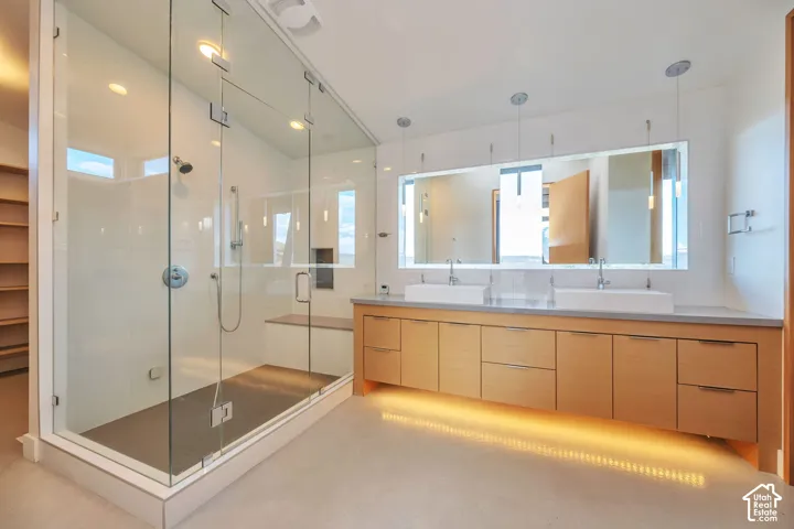 Expansive walk-in shower with clear glass enclosure and integrated bench