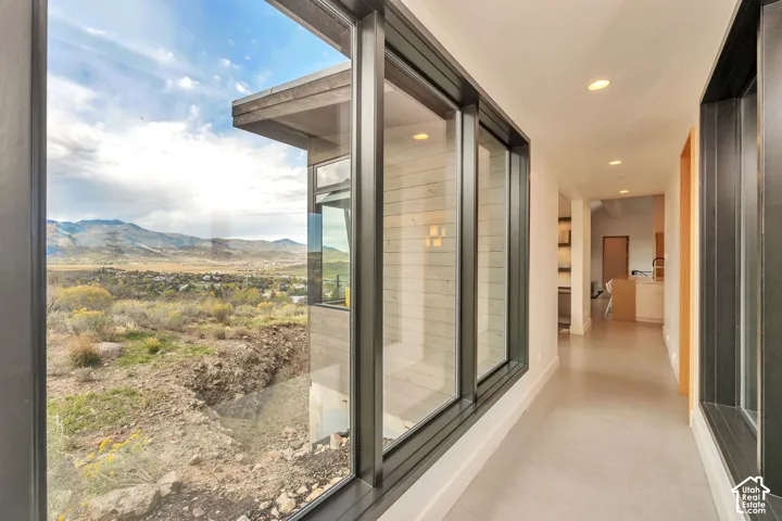 Expansive corridor with large format windows, recessed lighting, and smooth flooring