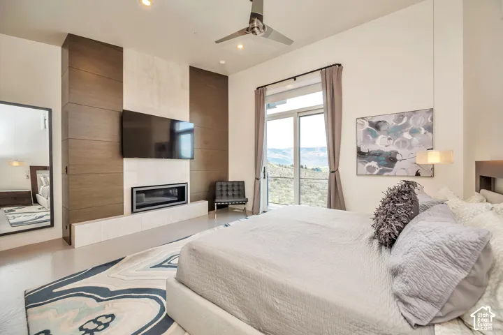 Integrated fireplace, wood-finish accent wall, glass sliding door, recessed lighting, and a ceiling fan