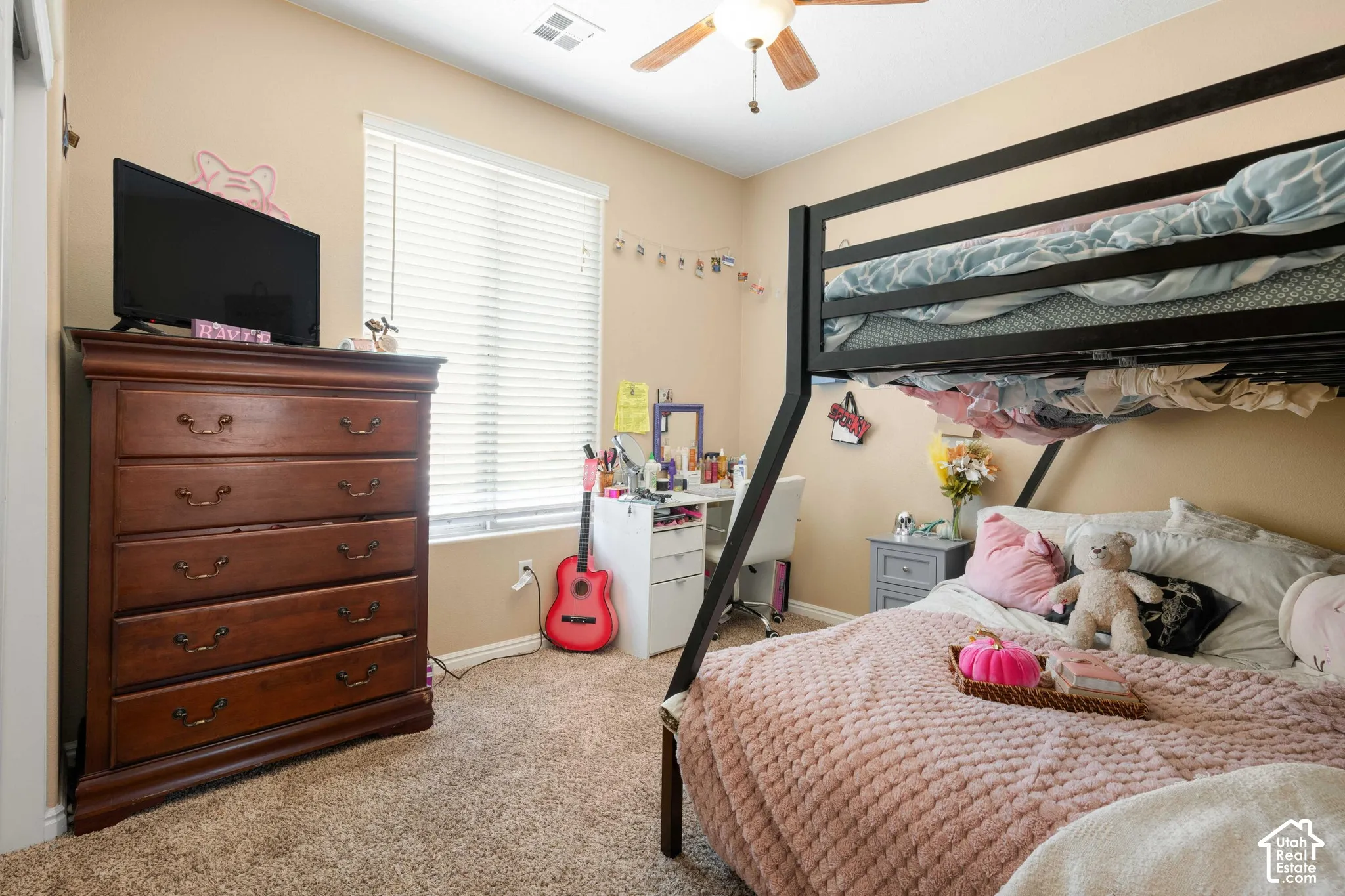Carpeted bedroom featuring a ceiling fan and window with blinds