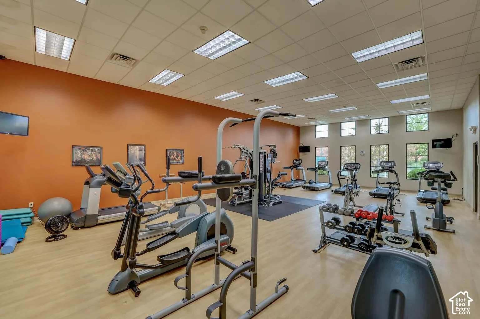 Fitness room featuring recessed lighting, paneled ceilings, wood-finish flooring, and multiple windows