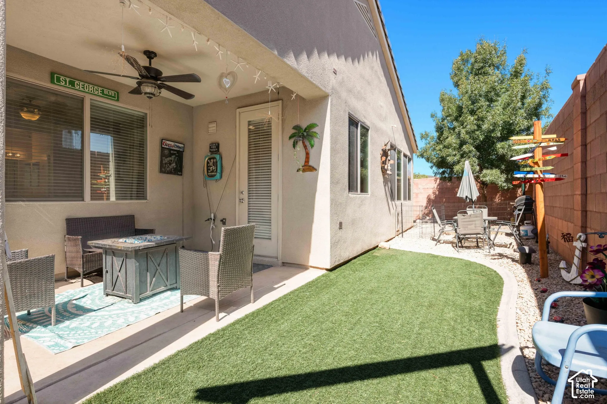 Patio with a ceiling fan, direct exterior access, and an adjacent low-maintenance artificial turf area