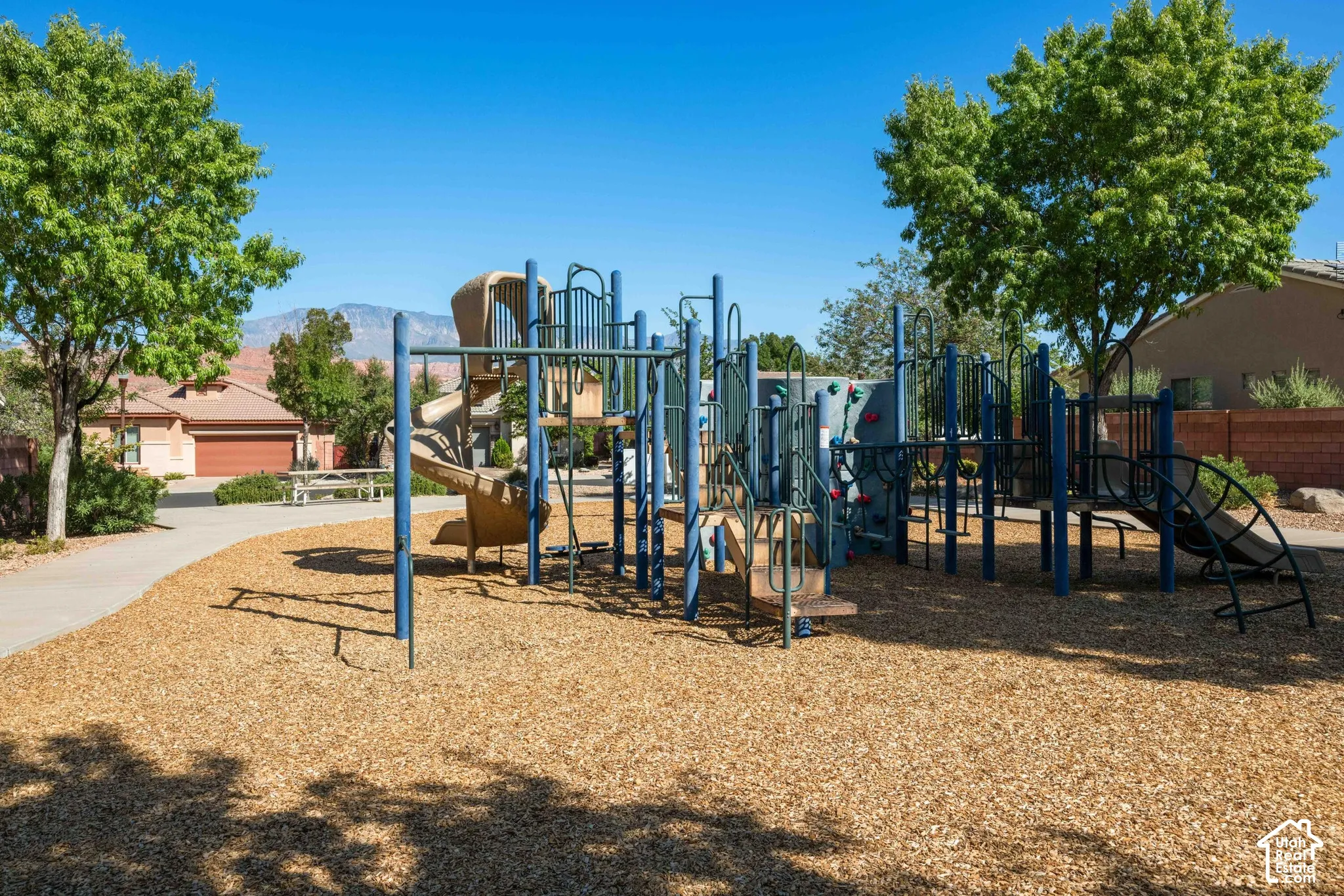 Community playground featuring a multi-level play structure, slides, and climbing elements