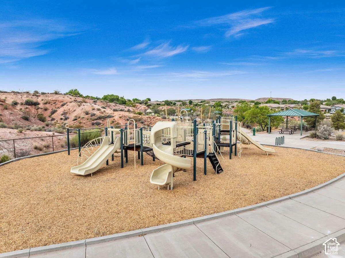 Playground area featuring multiple slides, climbing structures, and a wood chip surface