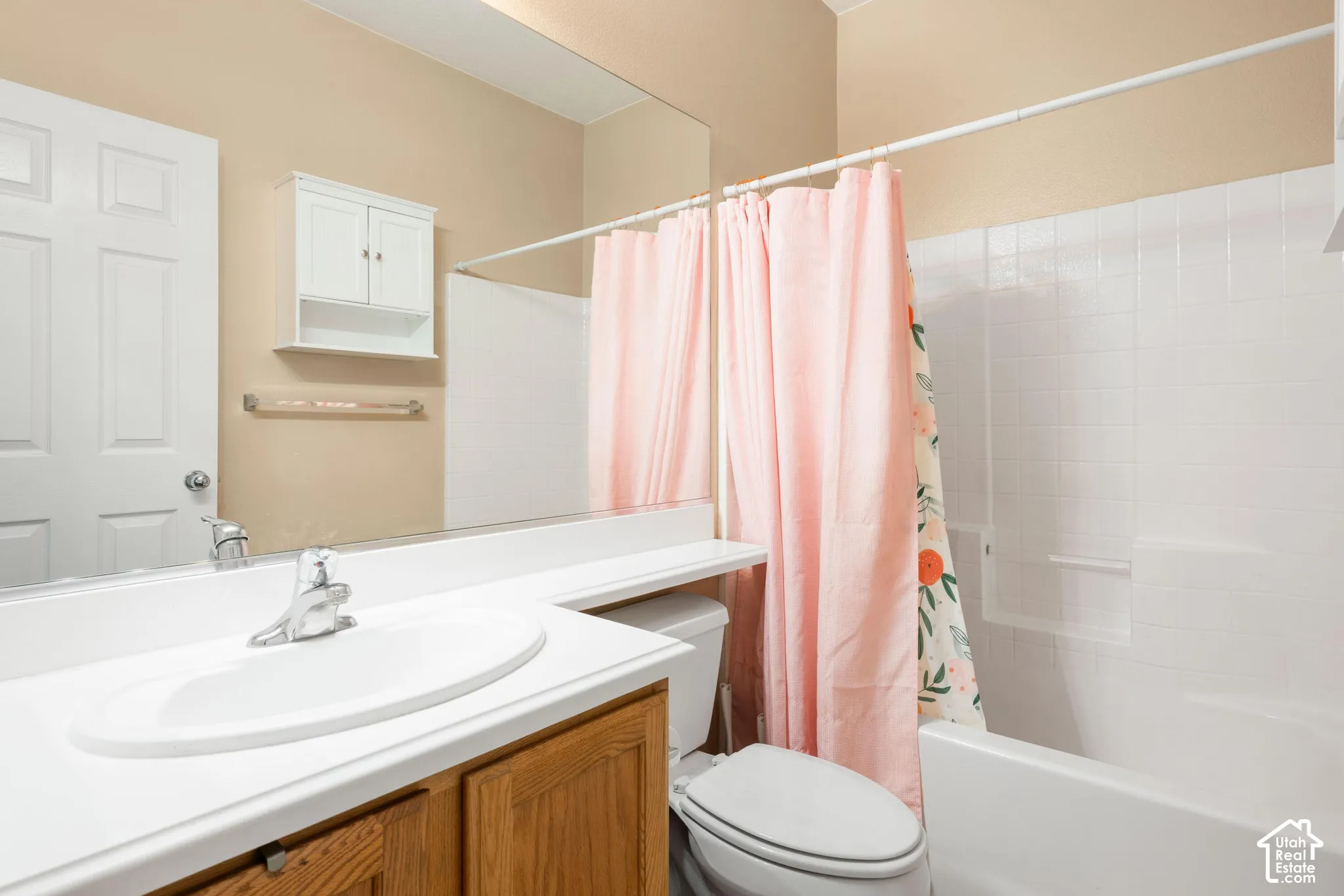 White vanity with an integrated sink, wood-finish cabinetry, and chrome fixtures