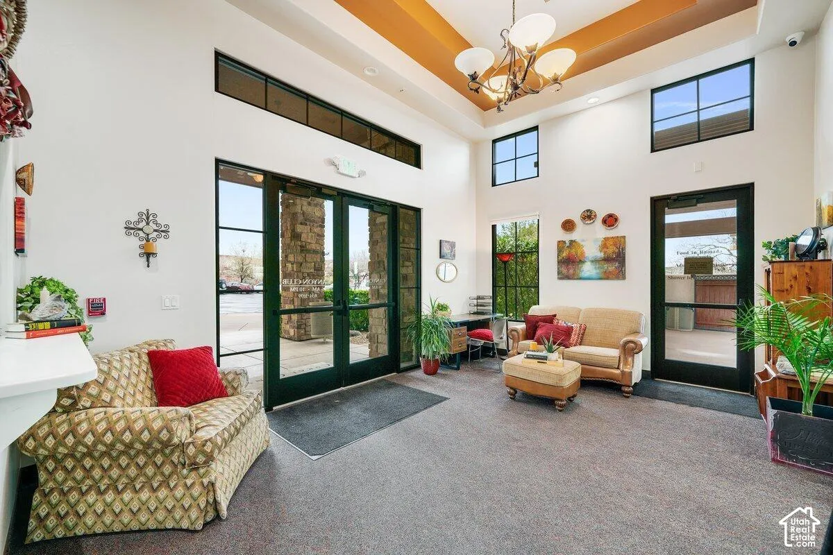 Expansive foyer with a high tray ceiling, recessed lighting, and a multi-arm chandelier