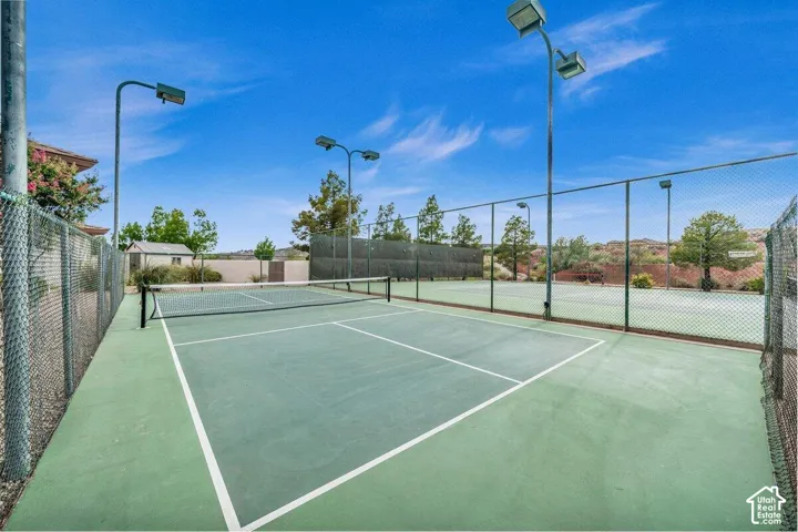 Outdoor court with green surface, white court lines, and chain-link fencing