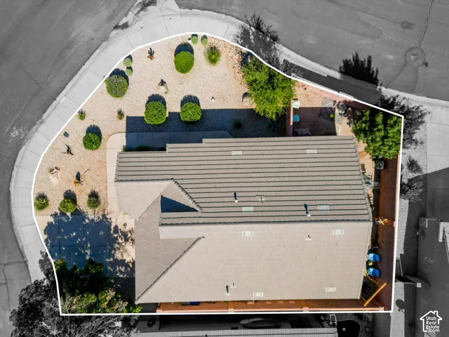 Property featuring a neutral-toned roof, desert landscaping, and a paved driveway